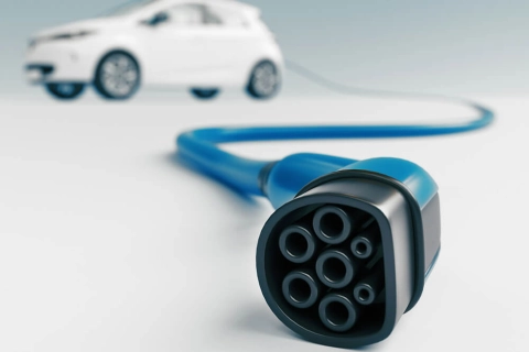 Ein Elektroauto wartet auf die Anmeldung, während das Ladekabel noch ungenutzt daneben liegt.